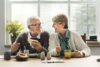 Älterer Mann und ältere Frau sitzen gemeinsam am Tisch und essen.